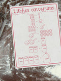 Red writing on printable kitchen conversion chart on a floured surface.