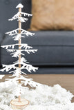 Close up photo of the smaller DIY paper Christmas tree siting on a piece of white cloth.