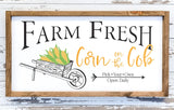 Wood sign with vintage wheelbarrow full of corn for fall.