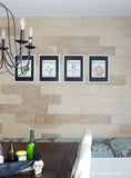 Printable Halloween art in white frames with black mats. Hanging on a wood plank wall in the dining room.
