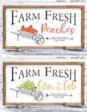 Two fall wood signs: one with peaches and one with corn in a wheelbarrow.