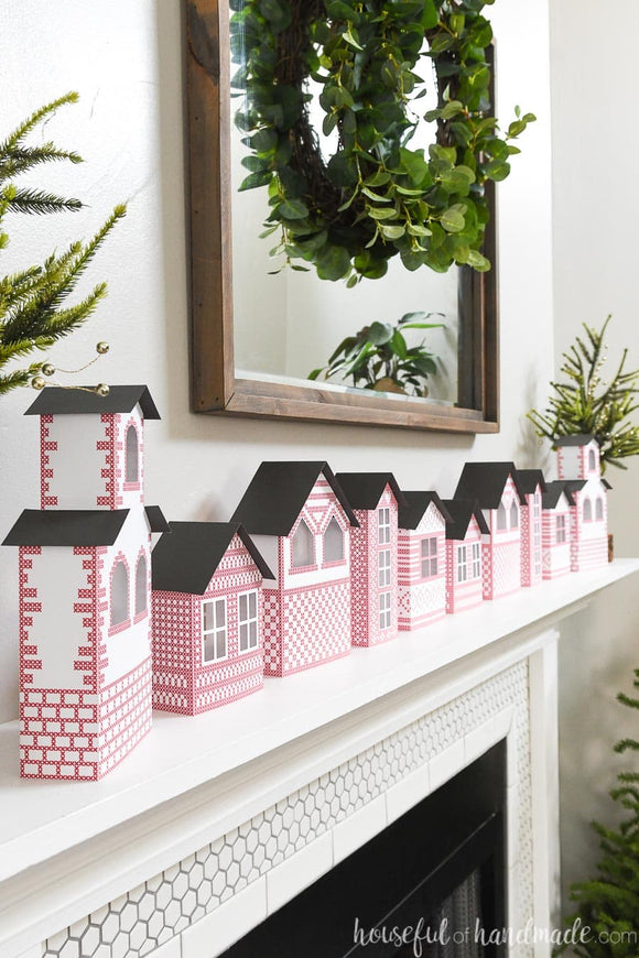 Fireplace decorated with an easy to make DIY Christmas village from paper.