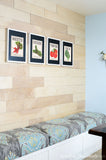 Wood wall with built in dining room bench and 4 vegetable seed packet art prints above it.
